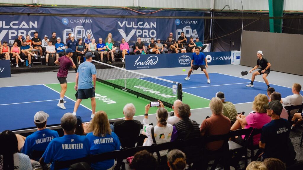 Professional doubles pickleball match on an indoor court