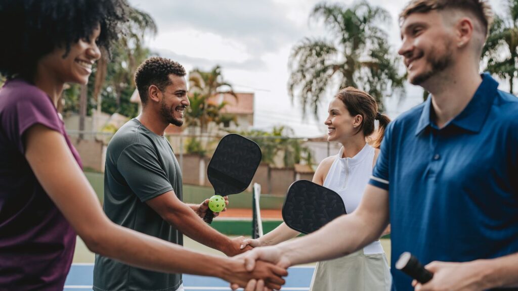 Players shaking hands after pickleball match outdoors
