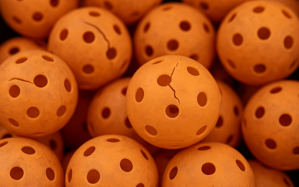 Close-up of cracked pickleballs collected for recycling
