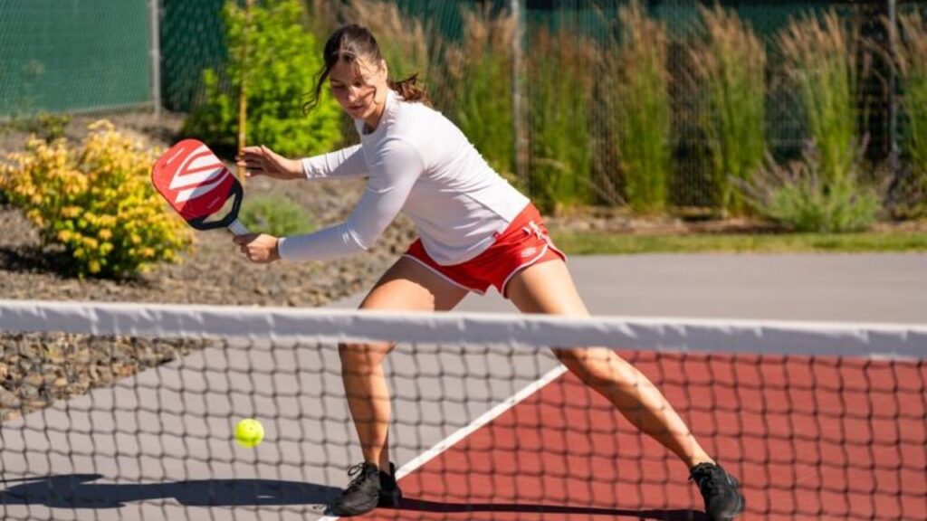 Female Pickleball player stepping on the line during play