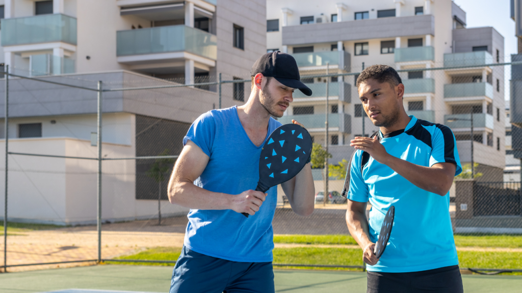 Pickleball coach teaching paddle grip to a beginner player