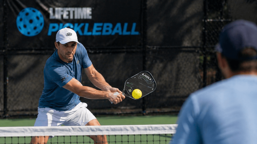 Pickleball player performing a controlled backhand volley at the net
